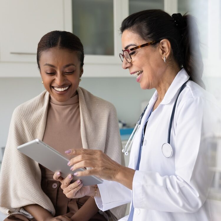 Happy practitioner and cheerful young patient watching examination medical report on tablet